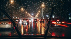 Cars in traffic during a rainy night seen through a windshield